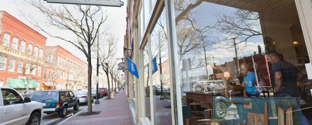 A view of shop windows and parked cars on Market Street in Corning, NY
