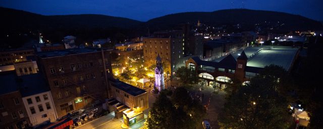 Drone view of a city center at night with lights illuminated