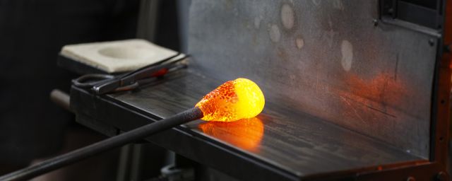 A gob of hot glass is rolled on a marver
